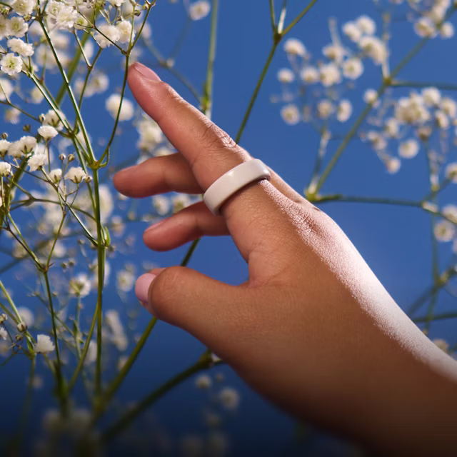 Nahaufnahme der Hand einer Person mit einem Cloud Oura Ring 4 Ceramic am Finger