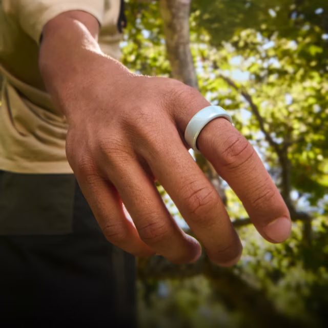 Nahaufnahme der Hand einer Person mit einem Tide Oura Ring 4 Ceramic am Finger