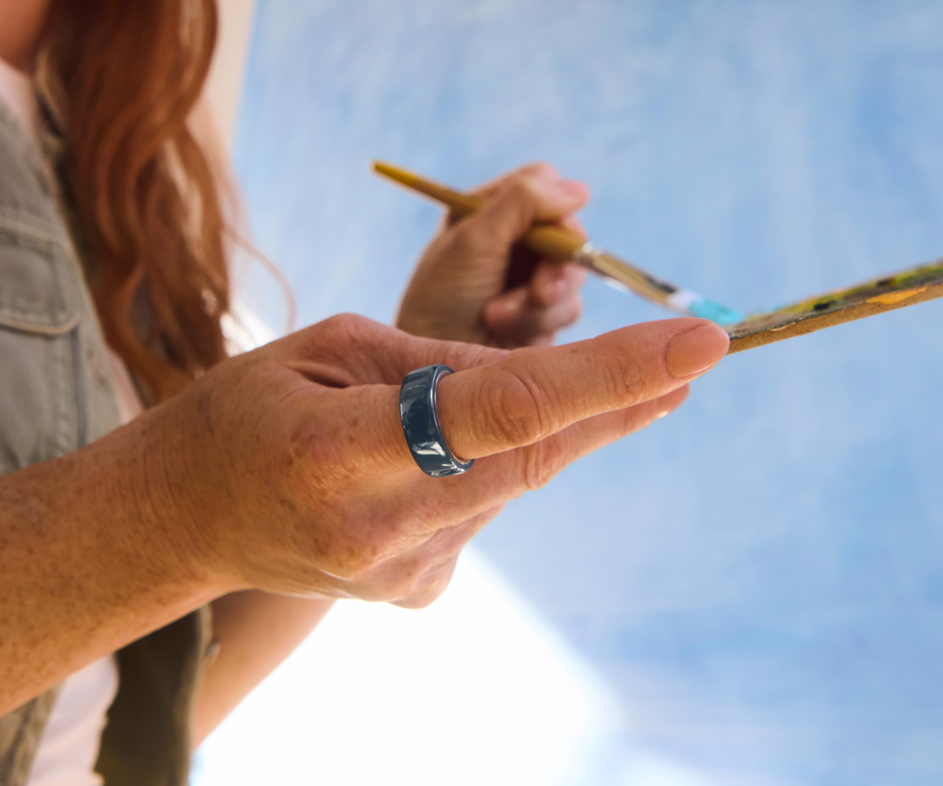 Nahaufnahme der Hand einer Person mit einem Midnight Oura Ring 4 Ceramic am Finger